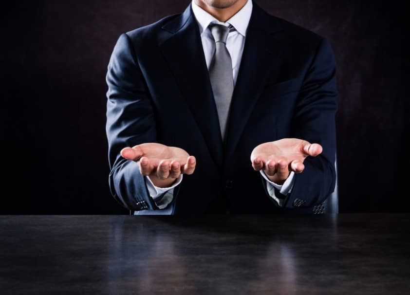 man in suit with hands extended